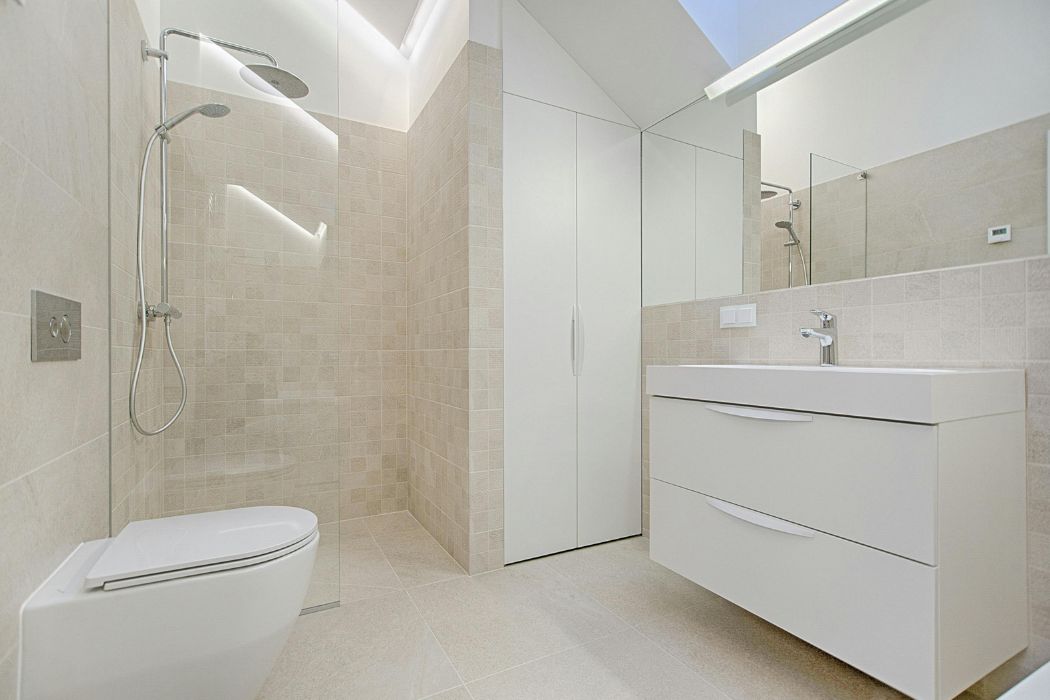 Lichte badkamer met glazen douchewand, wastafelmeubel en wandcloset