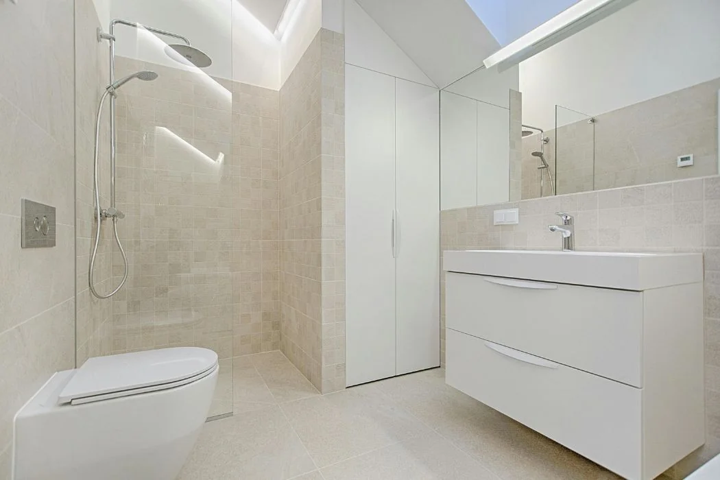 Lichte badkamer met inloopdouche, wandtoilet en wit wastafelmeubel van Aannemer M&S Bouwbedrijf